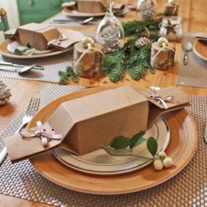 Plain kraft reusable Christmas crackers shown on a festive table